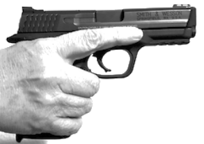 a pistol held in someone's hand with their finger off the trigger, resting on the frame of the gun.